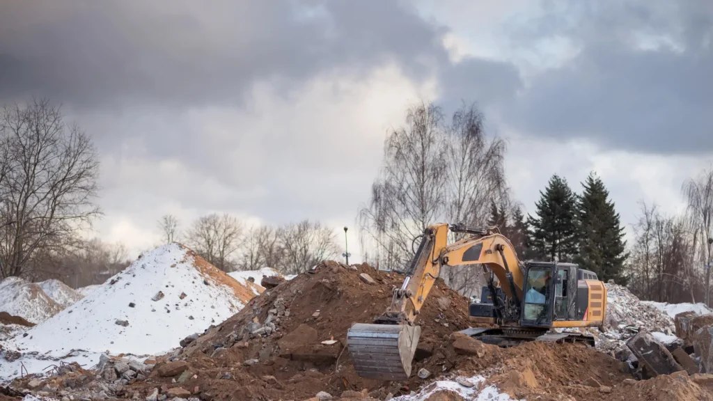 Excavator operating on dirt pile at active grading site